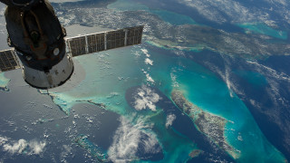 Satellite flying over water landforms - a satellite satellite free wallpaper