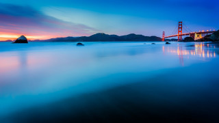 Long exposure bridge sunset mountain - a mountain in the background and a body of water free wallpaper