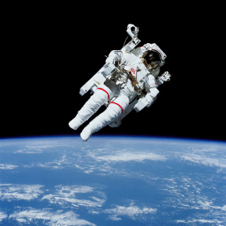 Astronaut floating above earth space - free space wallpaper