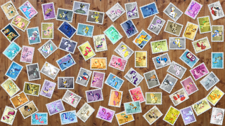 Stamps collection wooden table background - full color free wallpaper