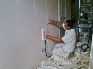 Man painting wall paint roller - his other hand free wallpaper