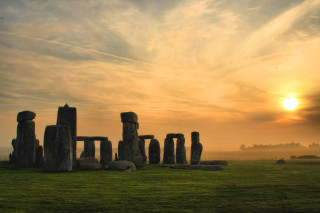 Stonehenges sunset field clouds sky - the sun setting behind them free wallpaper for desktop