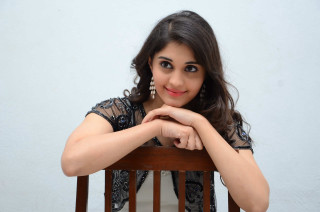 Woman sitting chair arms crossed 6 - a white wall behind her free wallpaper