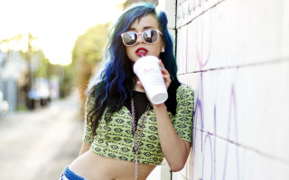 Woman blue hair sunglasses drinking - against a wall free wallpaper