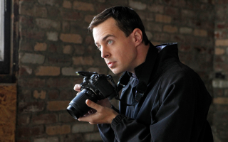 Man holding camera looking lens - the camera len free wallpaper