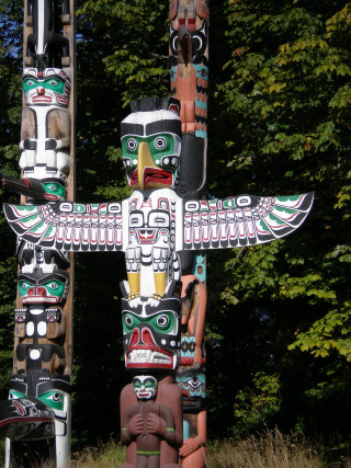 Totem statue forest trees bushes - ecological art free wallpaper for mobile