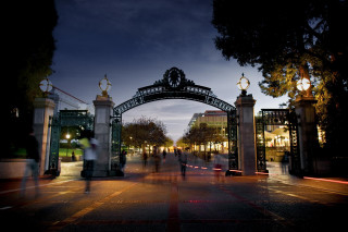 People walking metal arch nighttime - institutional free wallpaper