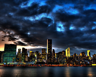 City skyline dark sky clouds 5 - a boat in the foreground free wallpaper for desktop