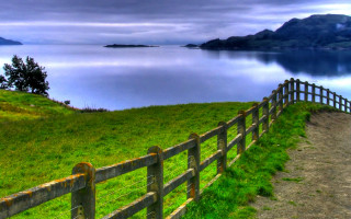 Wooden fence grassy hill lake 2 - a lake and mountains free wallpaper