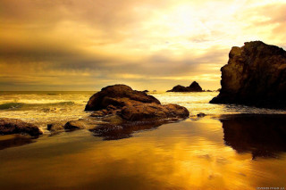 Rock formation beach sunset water 3 - a sunset in the background and a body of water free wallpaper