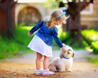 Little girl petting small dog 2 - a house in the background free wallpaper
