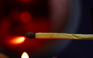 Matchstick lit candle red background - a candle free wallpaper