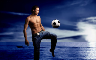 Man kicking soccer ball ocean - the water behind free wallpaper