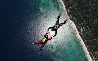 Parachute flying ocean city background - two person free wallpaper for desktop