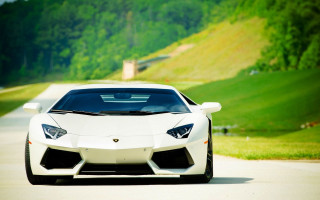 White sports car driving road 4 - a lush green hillside free wallpaper