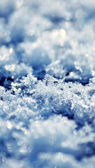 Snowflake closeup sunny day blue - free winter wallpaper for mobile