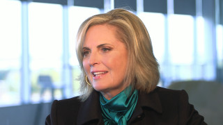 Blonde woman black jacket green - a window behind her free wallpaper for desktop