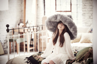 Woman sitting bed large hat - brown hair free wallpaper
