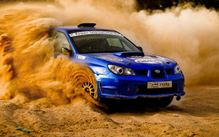 Blue subaru driving sandy area - dust free wallpaper