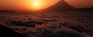 Sunset mountains clouds volumetric light - a sunset over a mountain range free wallpaper