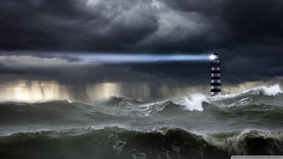 Lighthouse storm light beam ocean - a dark sky free wallpaper