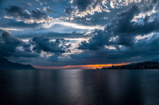 Sunset water clouds mountain trees - a sunset over a body of water free wallpaper