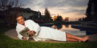 Man laying book pool house - a house in the background free wallpaper