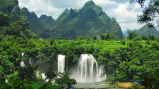 Waterfall lush forest mountain background - a waterfall in the middle free wallpaper