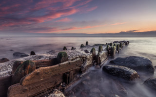 Sunset rocky beach pier water - a long exposure of a sunset over a rocky beach free wallpaper