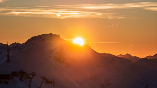 Ski lift mountain sunset ocean - over a mountain range in the distance free wallpaper
