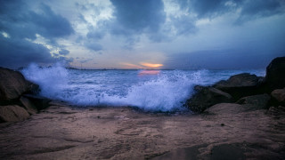Wave rocky beach sunset lighthouse - a lighthouse in the distance free wallpaper