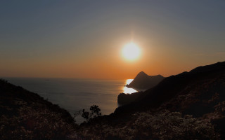 Sunset ocean mountain city lights - a mountain in the background and a body of water free wallpaper