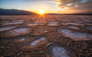 Sunset mountain field clouds ocean - a mountain range in the distance free wallpaper