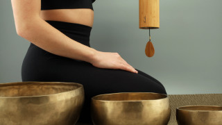 Woman sitting singing bowls pendulum - the wall behind her free wallpaper