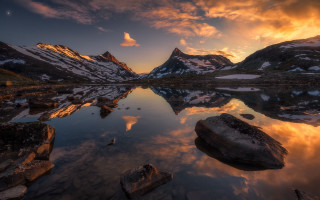 Mountain lake rocks sunset clouds - the foreground and a sunset in the background free wallpaper for desktop