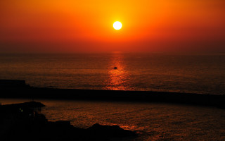 Sunset ocean boat person mountain - a sunset over the ocean free wallpaper