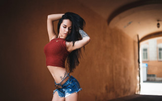 Woman red top blue shorts - a brick wall free wallpaper