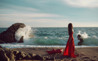 Woman red dress beach ocean 4 - a rock formation in the background free wallpaper