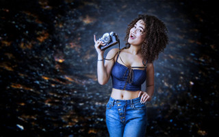 Woman camera smiling dark background - a black background behind her free wallpaper