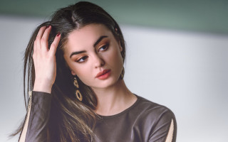 Woman longhair brownshirt handonhead lookingatcamera - a brown shirt free wallpaper for desktop