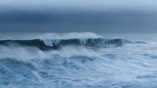 Stormy ocean wave surfing cloudy - a dark sky above free wallpaper
