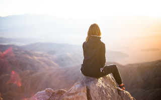 Woman sitting valley mountains sunset - sense of awe free wallpaper