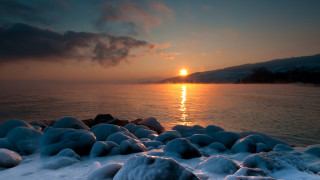Sunset water snow rocks mountain - the foreground and a mountain in the background free wallpaper