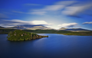 Mountain lake island clouds sky - a small island in the middle of the water free wallpaper