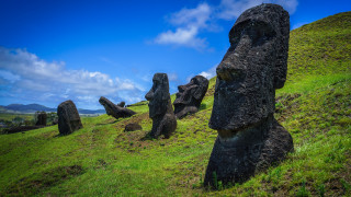 Rocky hilltop green field statue - a lush green field of grass free wallpaper