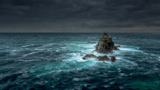 Rock outcropping ocean dark sky - stormy weather free wallpaper