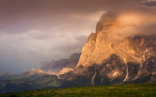 Mountain peak cloudy sky green - a green field below free wallpaper