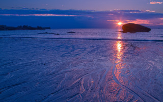 Sunset water rock distant bridge - a sunset over a body of water free wallpaper