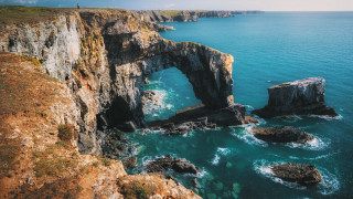 Ocean rock formation person stand - over the water free wallpaper