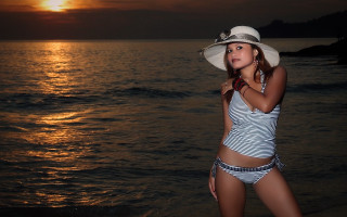 Beach sunset woman bikini hat - the ocean in the background free wallpaper